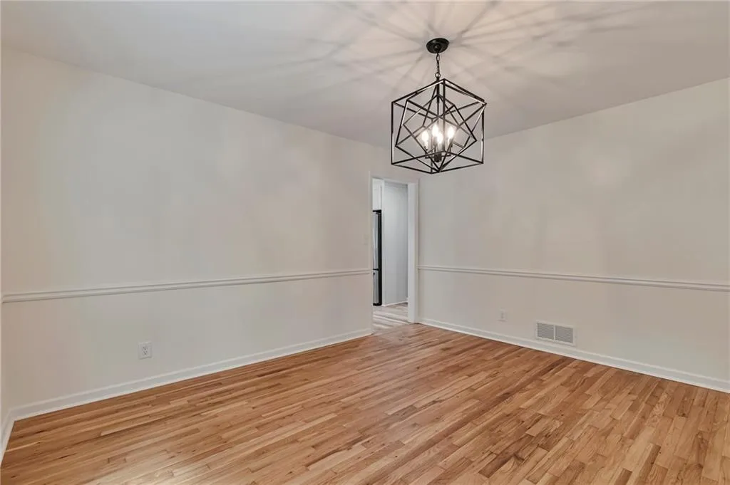 Unfurnished dining area featuring a chandelier and light hardwood / wood-style floors