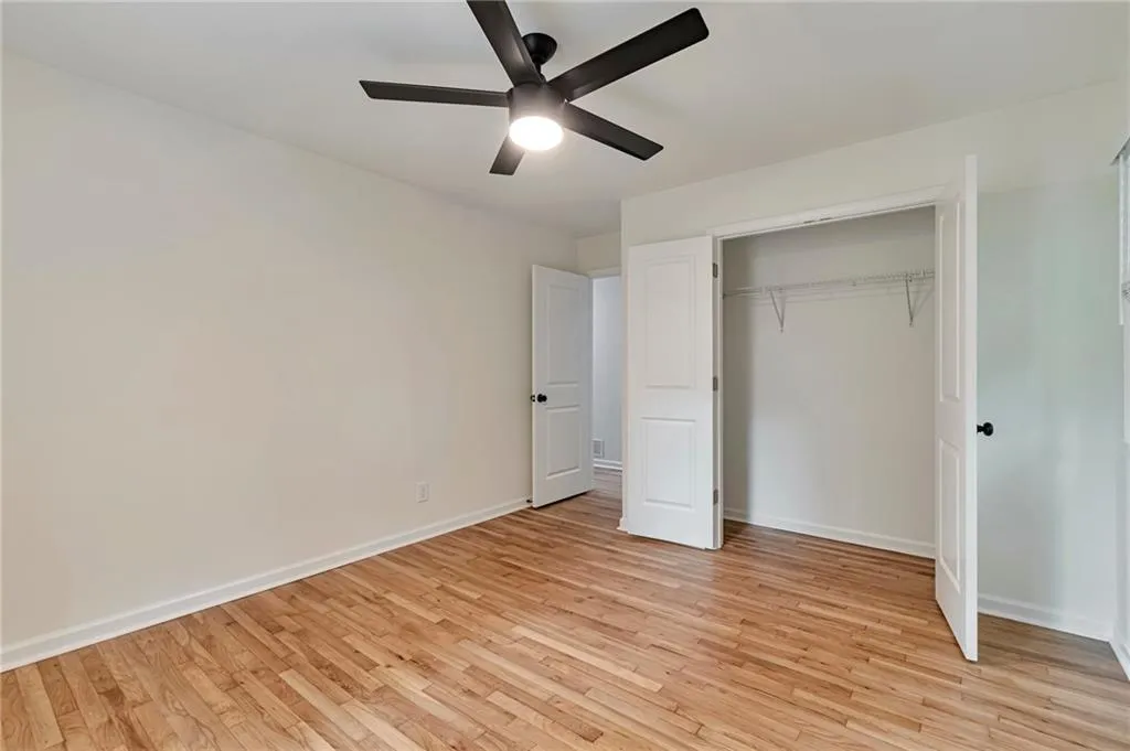 Unfurnished bedroom featuring light wood-type flooring, ceiling fan, and a closet
