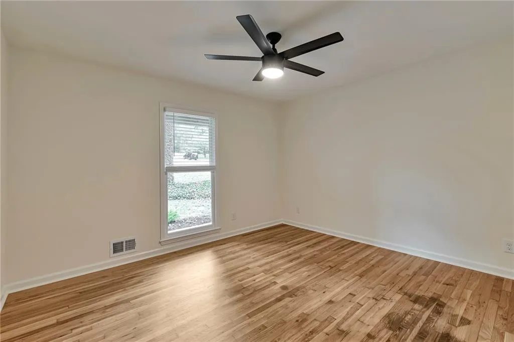 Empty room featuring light wood-type flooring and ceiling fan