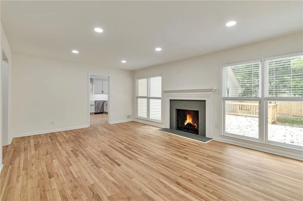 Unfurnished living room with a brick fireplace and light hardwood / wood-style floors
