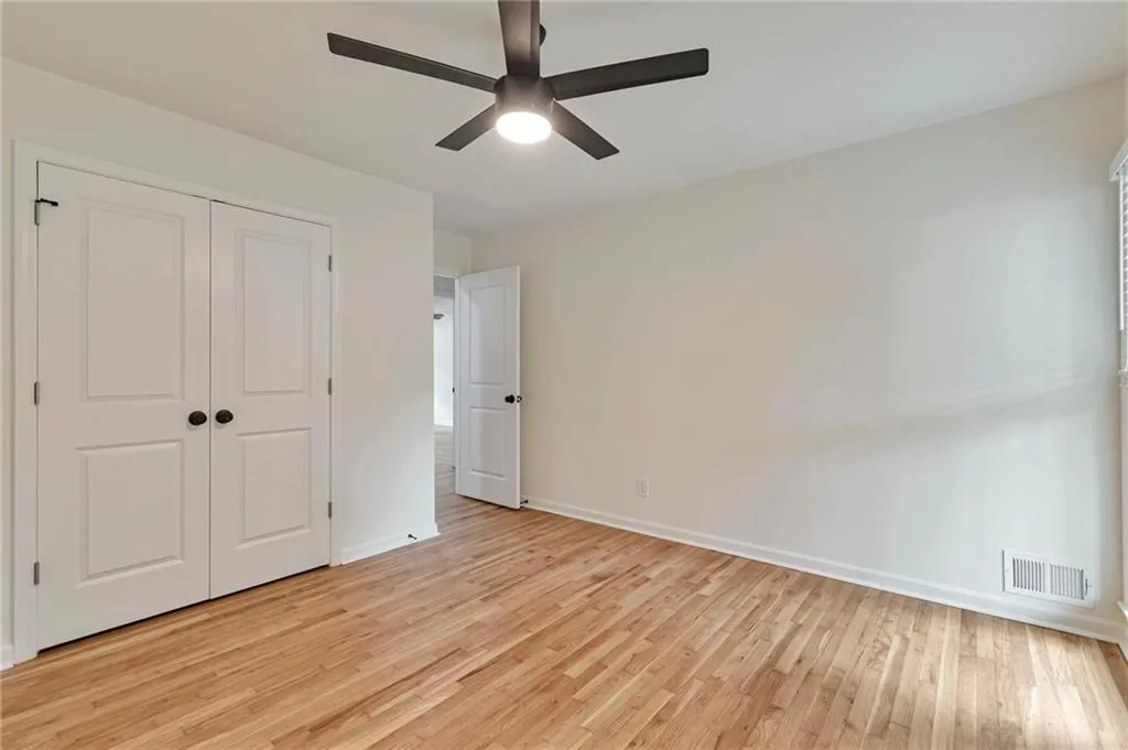 Unfurnished bedroom featuring ceiling fan, a closet, and light wood-type flooring
