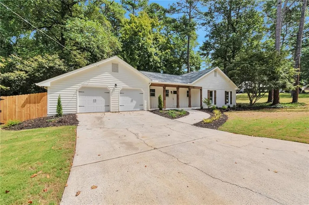 Ranch-style home featuring a garage and a front lawn