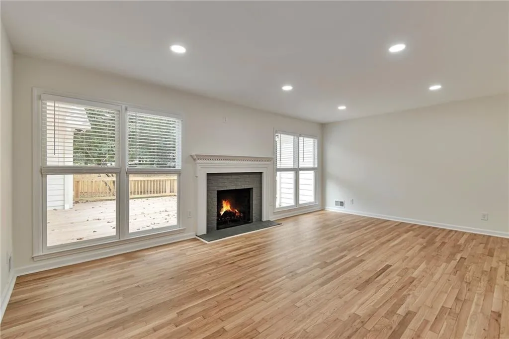 Unfurnished living room with a brick fireplace and light hardwood / wood-style floors