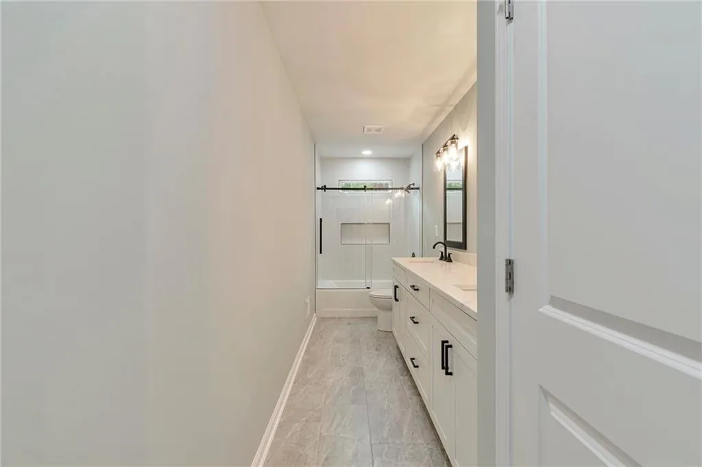 Full bathroom featuring vanity, toilet, and enclosed tub / shower combo