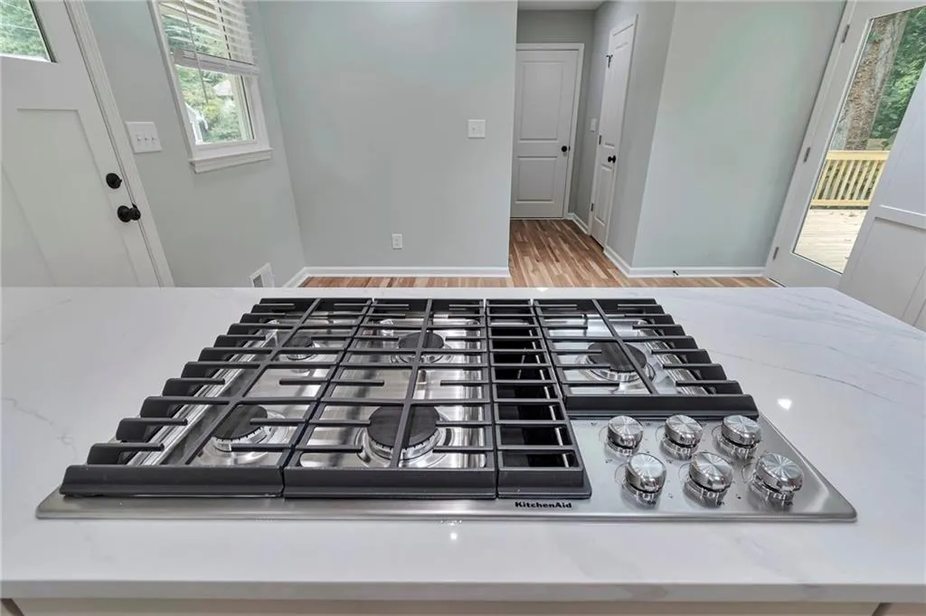 Details featuring stainless steel gas stovetop and hardwood / wood-style flooring