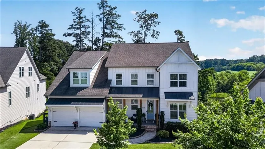 Contemporary farmhouse architecture with white vertical siding and dark trim