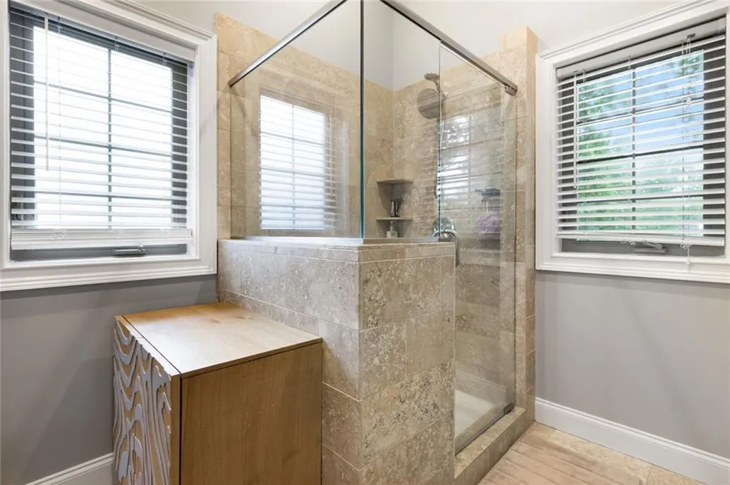 Bathroom featuring a stall shower and baseboards