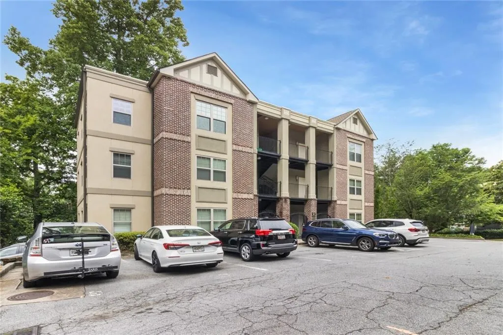 View of apartment building / complex with uncovered parking