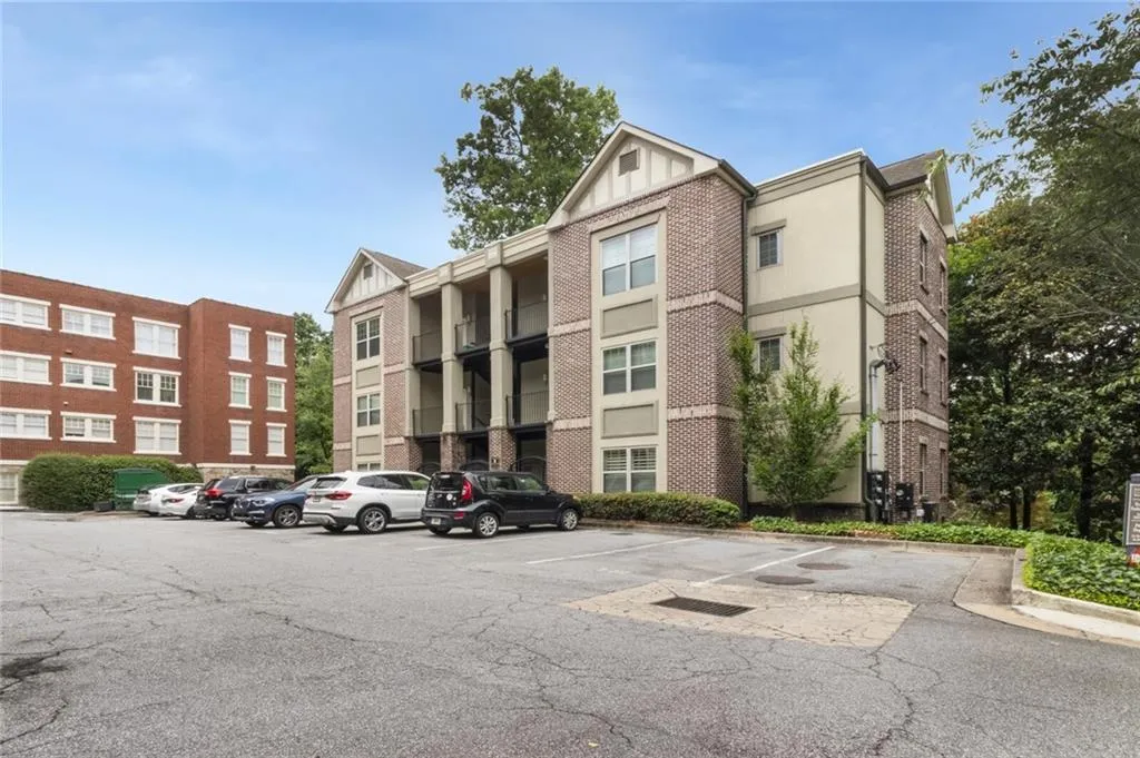 View of apartment building / complex featuring uncovered parking