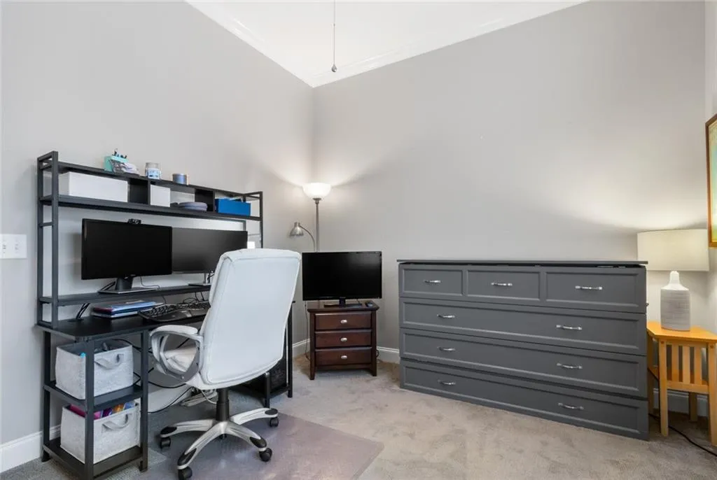 Home office featuring light carpet and ornamental molding