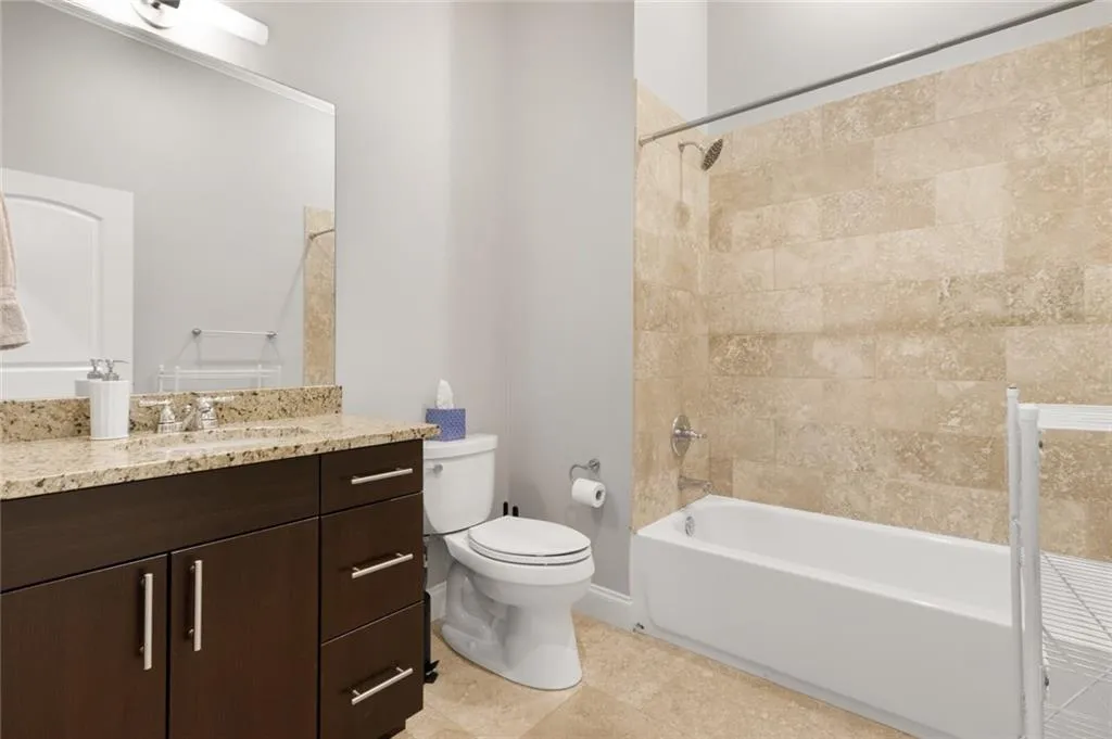 Full bath featuring vanity, shower / bathtub combination, and light tile patterned flooring