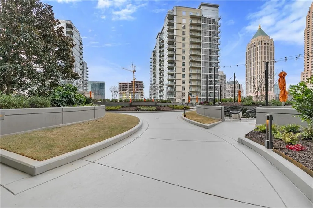 Expansive concrete patio area with raised planters, integrated lighting, and string lights