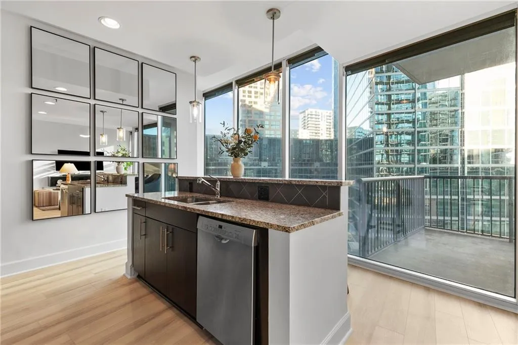 Kitchen island with granite countertop, stainless steel dishwasher, and built-in sink