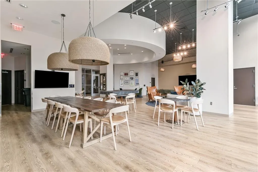 Expansive common area featuring wood-finish flooring, high ceilings, recessed lighting, and track lighting