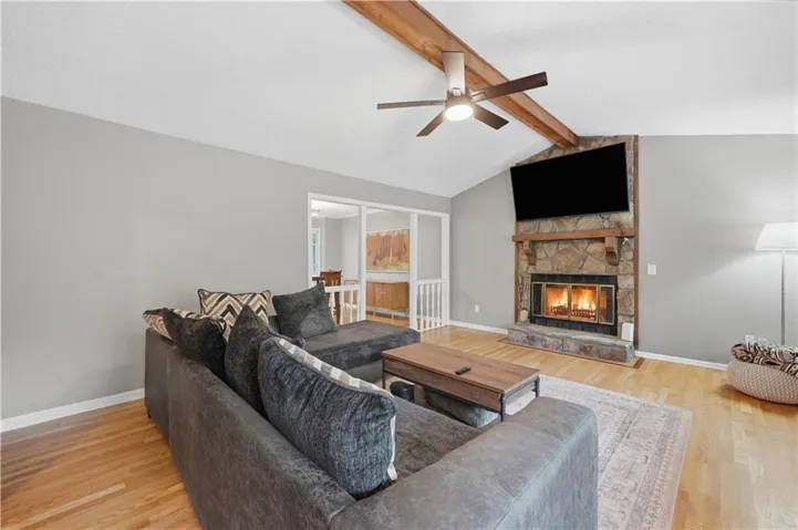 Vaulted ceiling with exposed wood beams and a ceiling fan