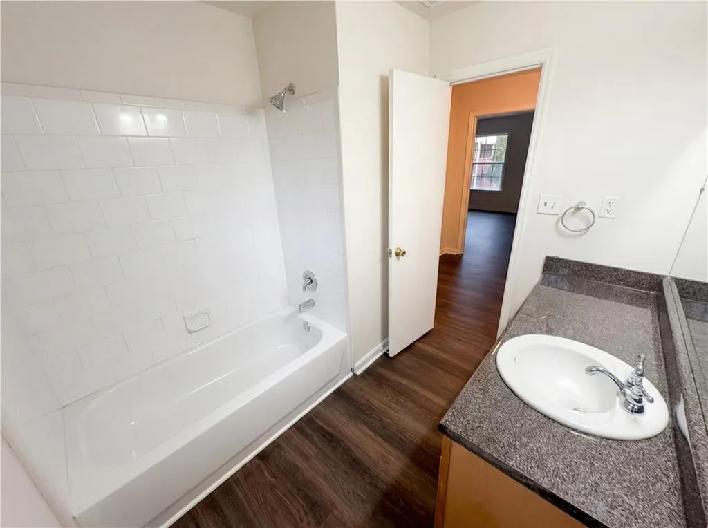 Full bathroom featuring vanity, dark wood-style flooring, and tub / shower combination