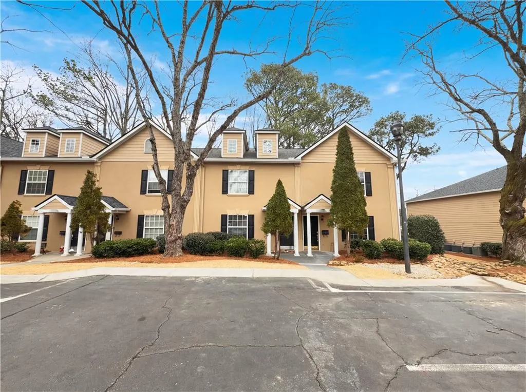 Traditional-style home with uncovered parking and stucco siding