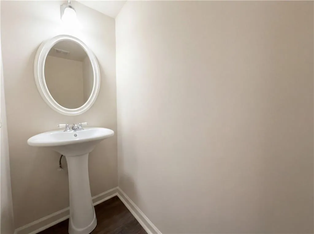 Bathroom with baseboards and dark wood-type flooring