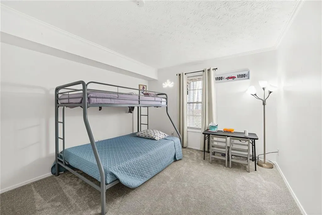 Bedroom with carpet and a textured ceiling