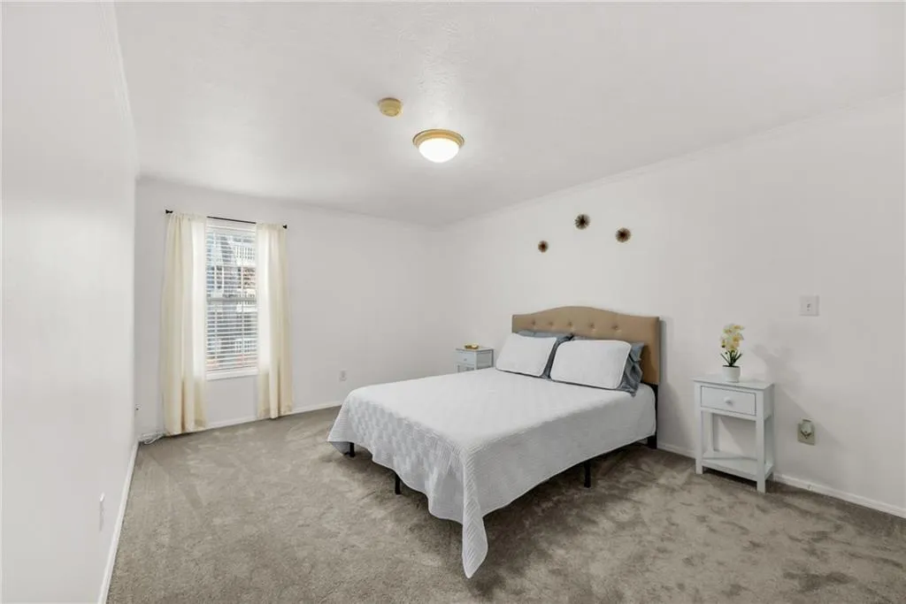 Carpeted bedroom with ornamental molding