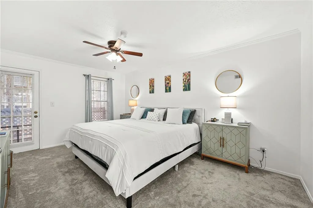 Carpeted bedroom with crown molding, a ceiling fan, and access to exterior
