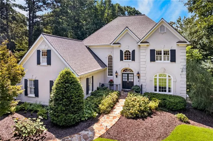 Elegant Entry with prominent gables and a stone pathway