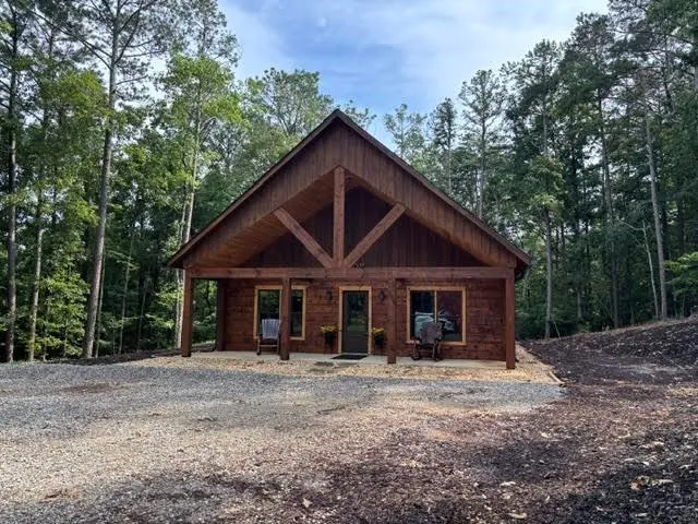 Crafted wood siding and a covered front porch featuring exposed beam architectural details