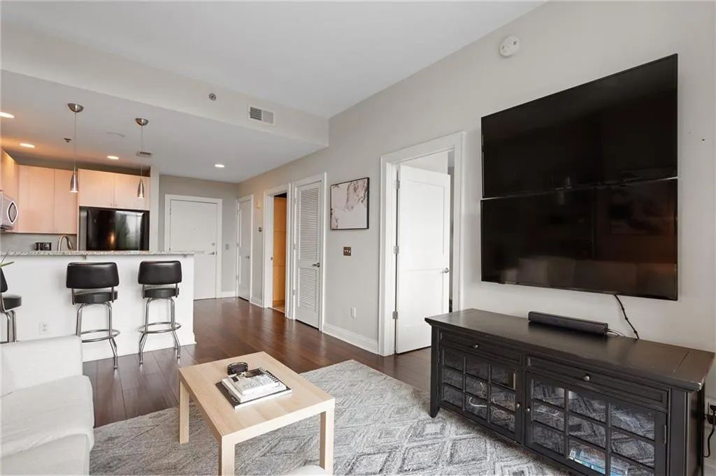 Living area with dark wood-style floors and recessed lighting