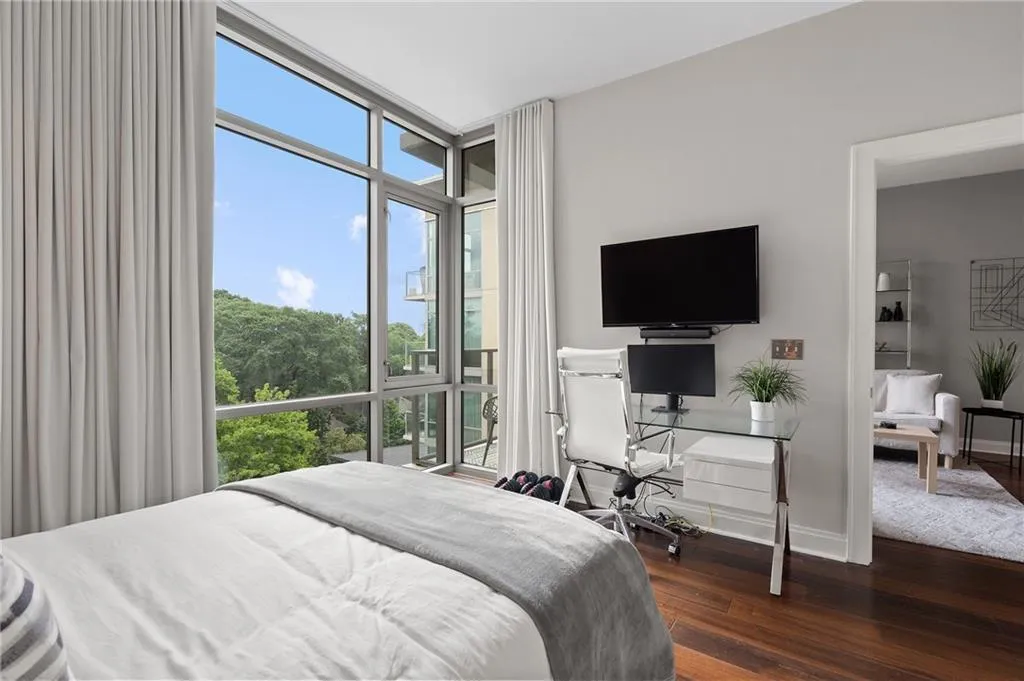Bedroom featuring dark wood-style flooring and floor to ceiling windows