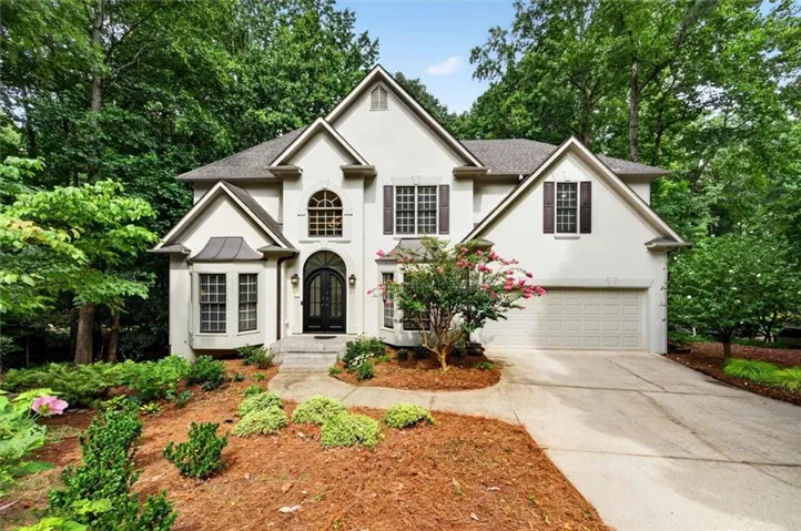 Stucco exterior with multiple gables and dark shutters