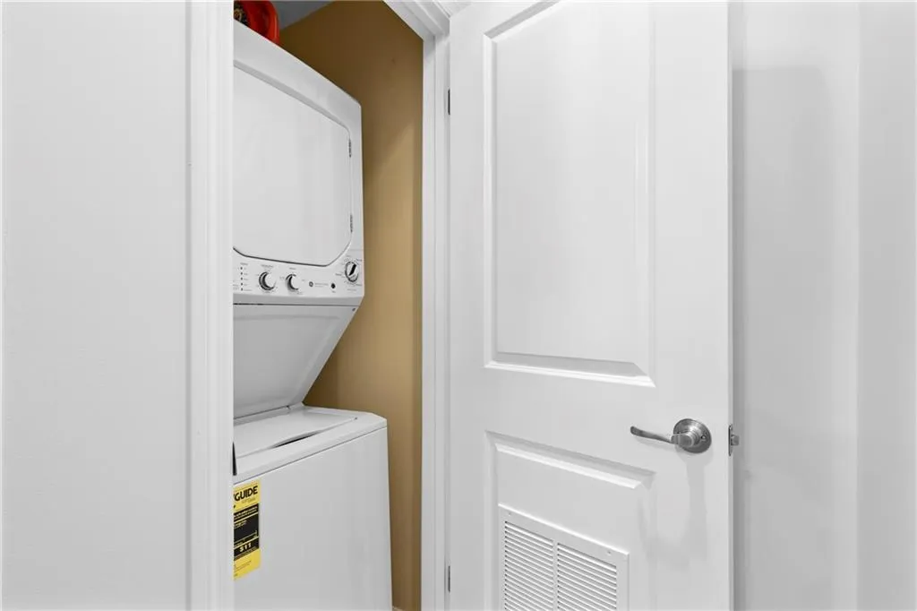 Laundry area with stacked washing machine and dryer