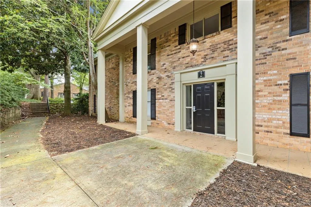 Entrance to property with covered porch and brick siding