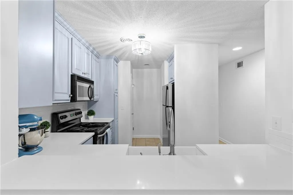 Kitchen with a tasteful backsplash, modern lighting, and light tile patterned floors