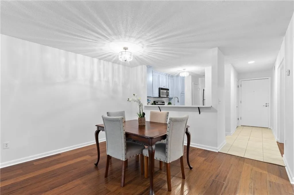 Dining room featuring dark wood-style floors and a chandelier