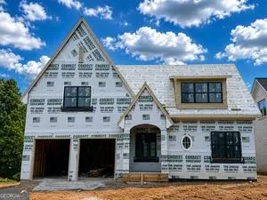 New construction residence featuring a two-car garage, multiple gables, and a window dormer