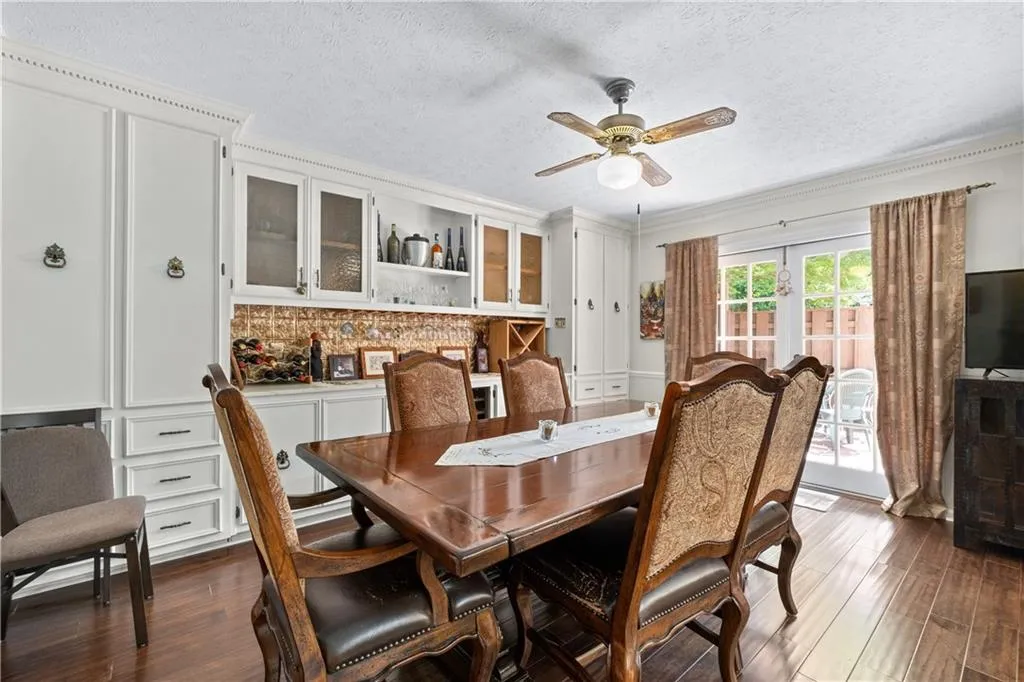 Dining room with dark hardwood / wood-style flooring, ceiling fan, a textured ceiling, and crown molding