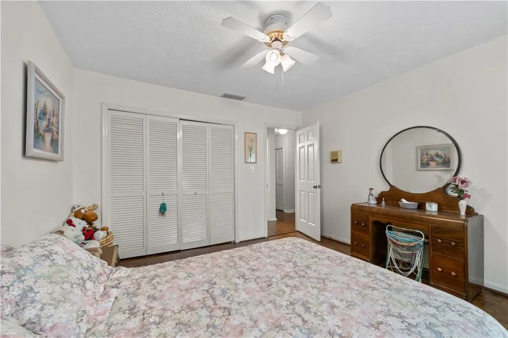 Bedroom with dark hardwood / wood-style flooring, a closet, and ceiling fan