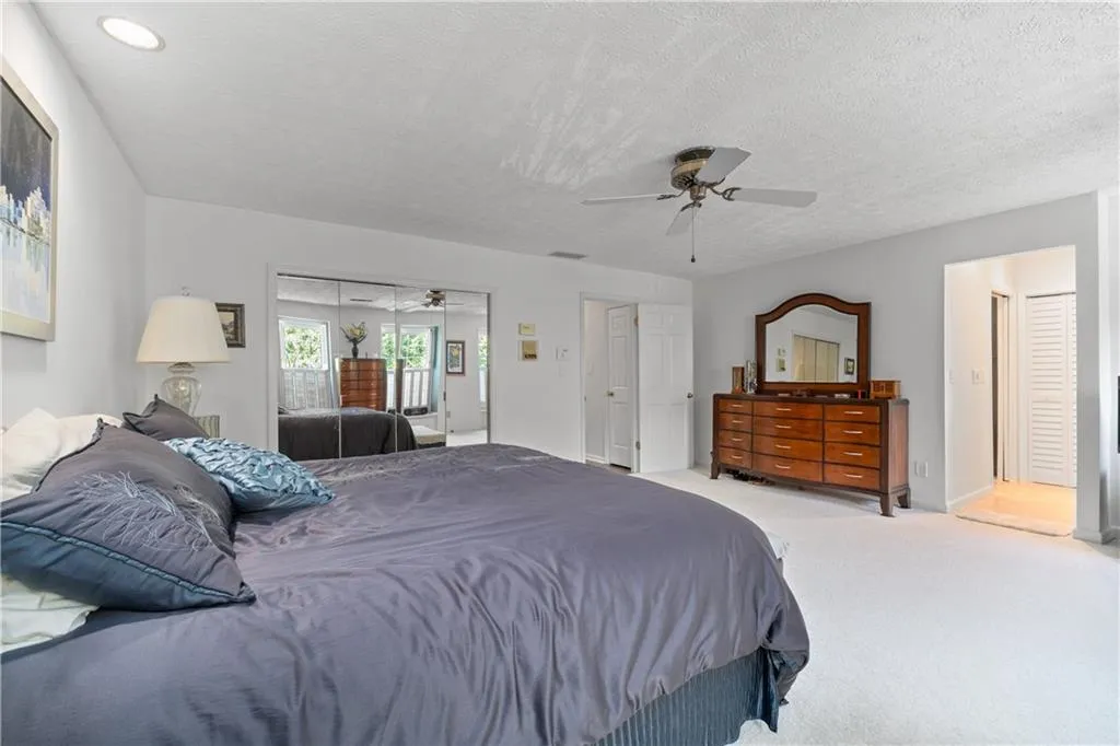 Bedroom featuring a textured ceiling, ceiling fan, and carpet floors