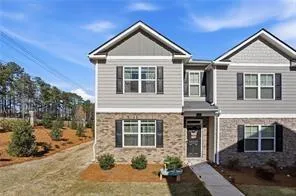 Duplex exterior featuring gray siding and stone veneer accents