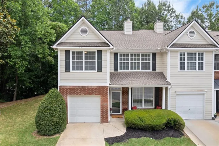 WELCOME HOME!! Two-story townhome featuring light-toned siding and brick accents