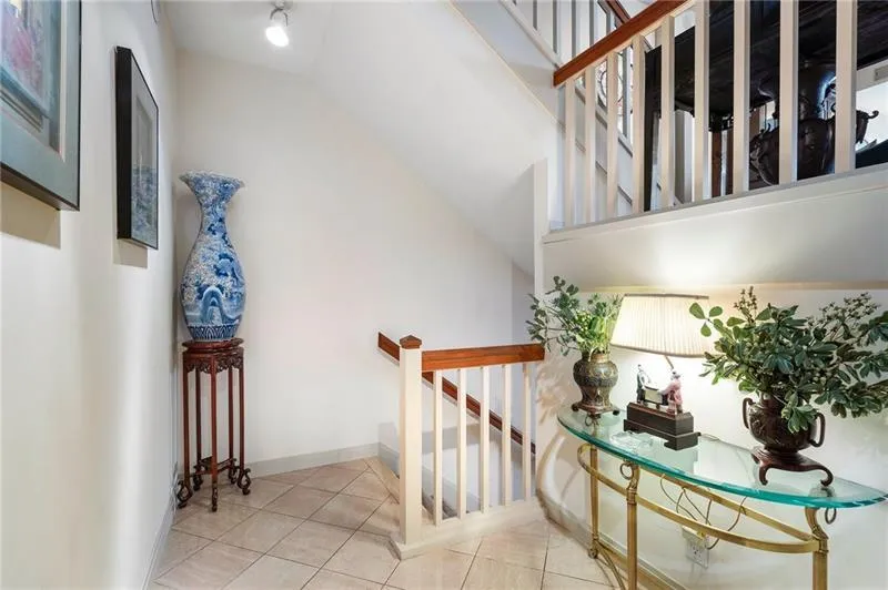 Staircase featuring tile patterned flooring, baseboards, and vaulted ceiling