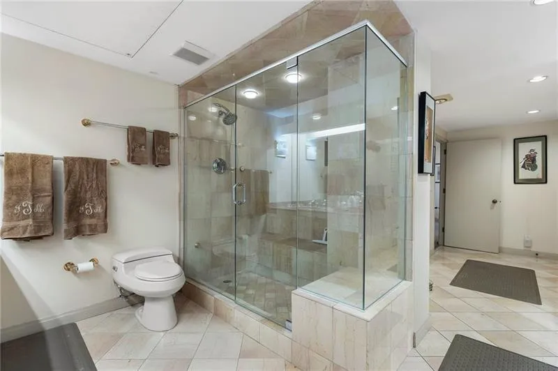 Bathroom with toilet, a shower stall, visible vents, and tile patterned flooring