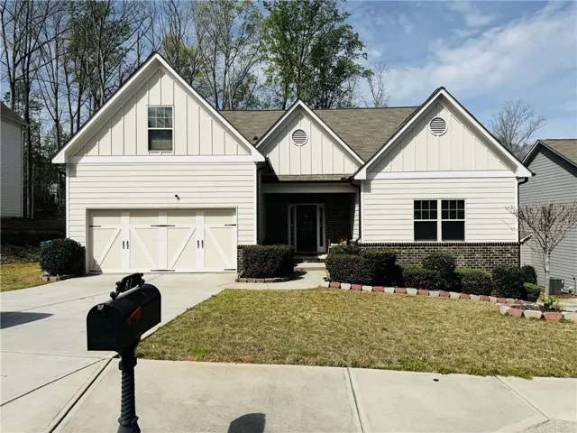 The property features a light-colored exterior with a brick foundation and a dark roof