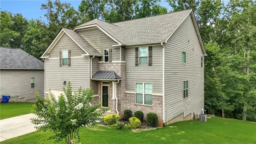 Two-story residence featuring a combination of horizontal siding, shake siding, and brick accents