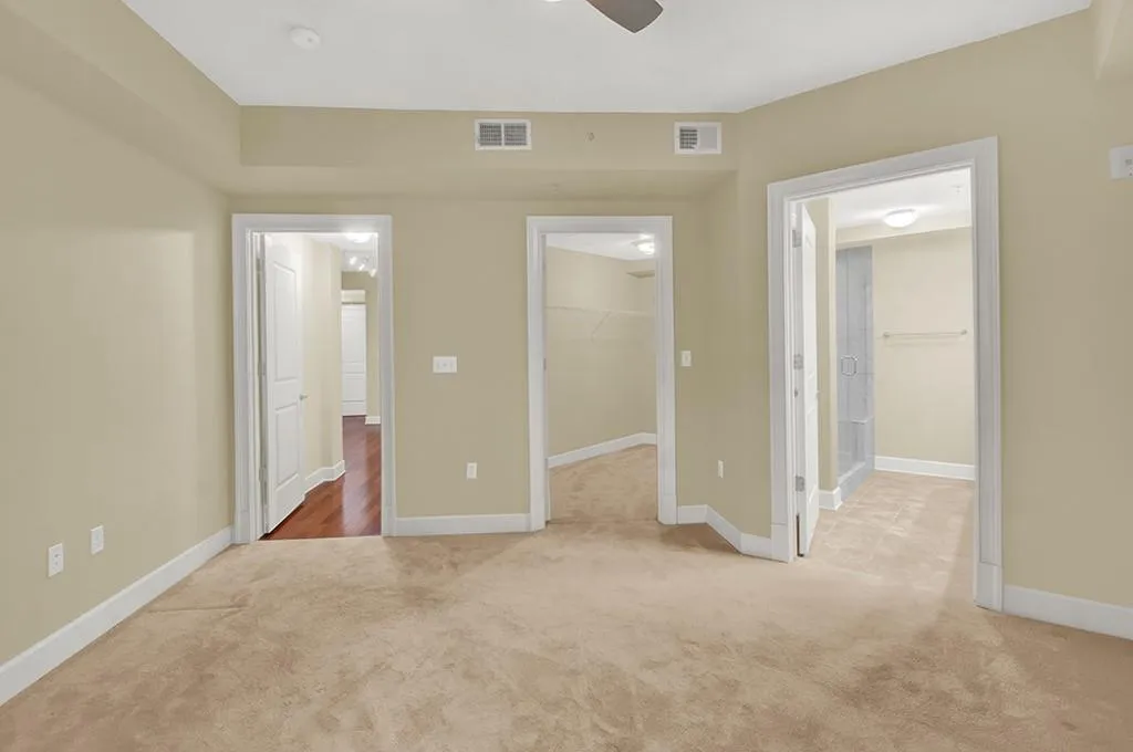 Unfurnished bedroom with light hardwood / wood-style floors, a spacious closet, a closet, and ceiling fan