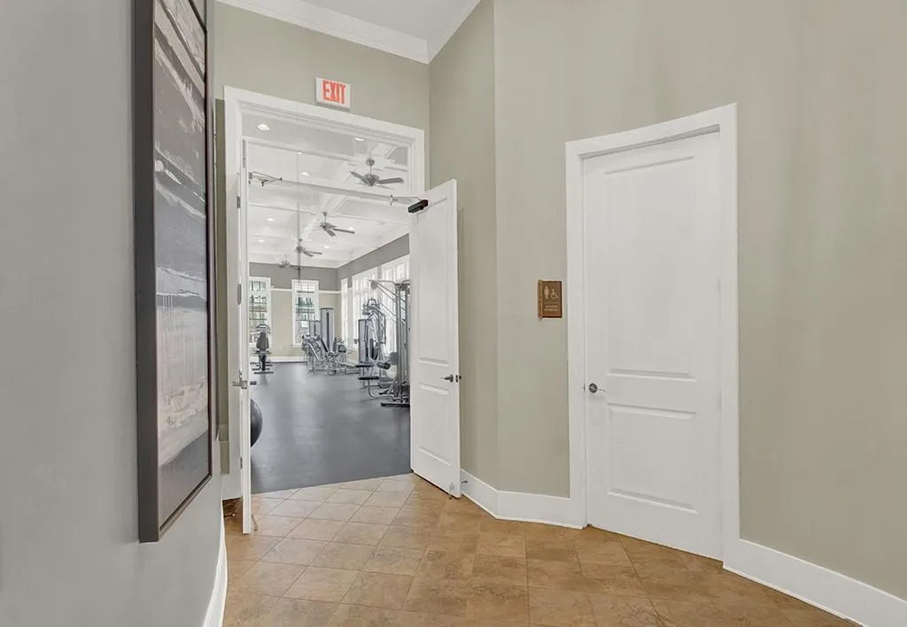 Hallway featuring light tile floors and crown molding