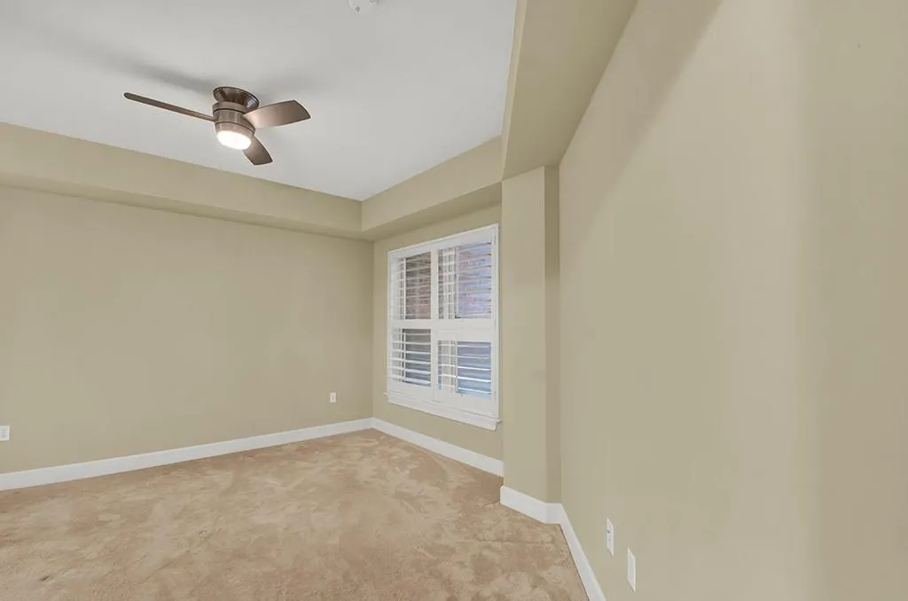 Spare room with ceiling fan and light colored carpet