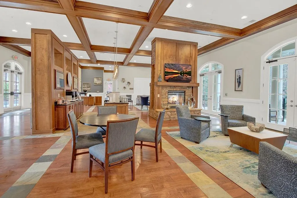 Dining area with french doors, coffered ceiling, a fireplace, and light wood-type flooring