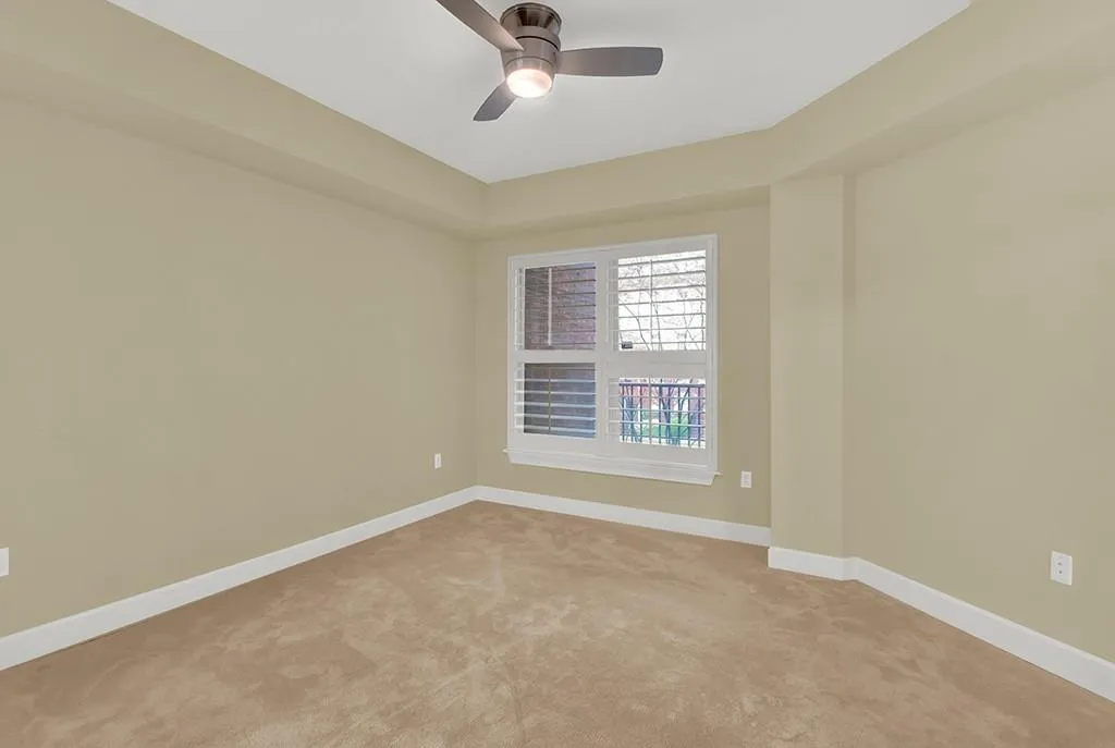 Unfurnished room featuring light colored carpet and ceiling fan