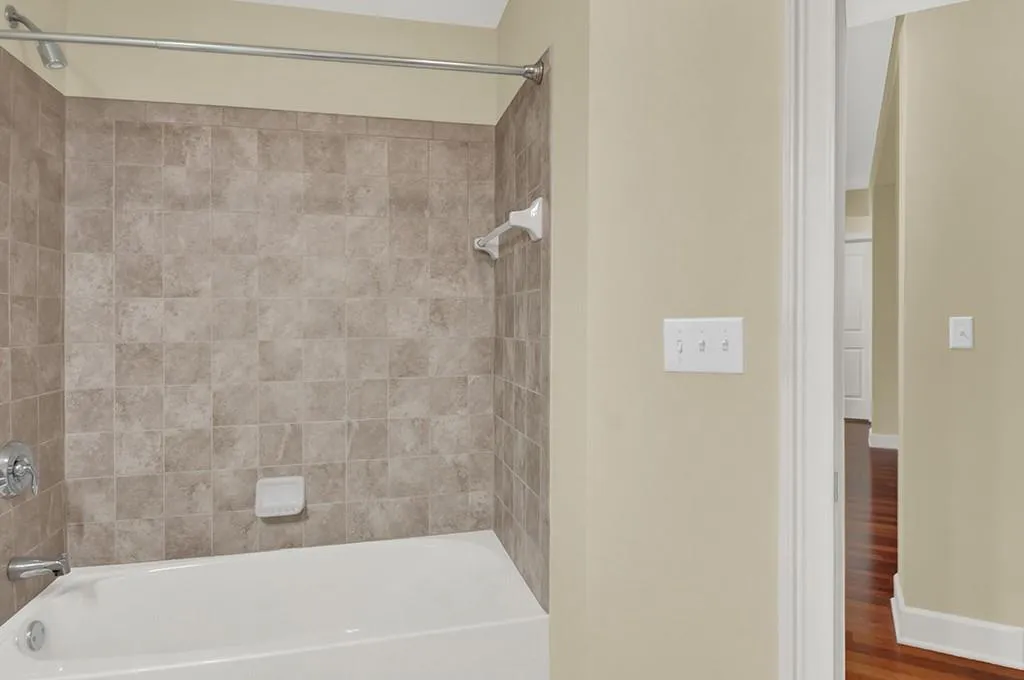 Bathroom featuring tiled shower / bath combo and hardwood / wood-style floors
